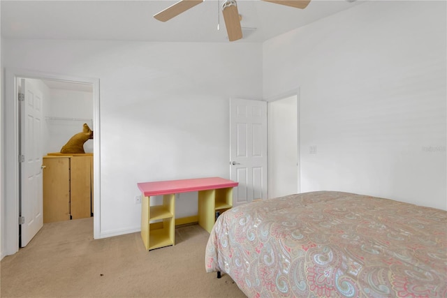 bedroom featuring ceiling fan, a spacious closet, light colored carpet, vaulted ceiling, and a closet