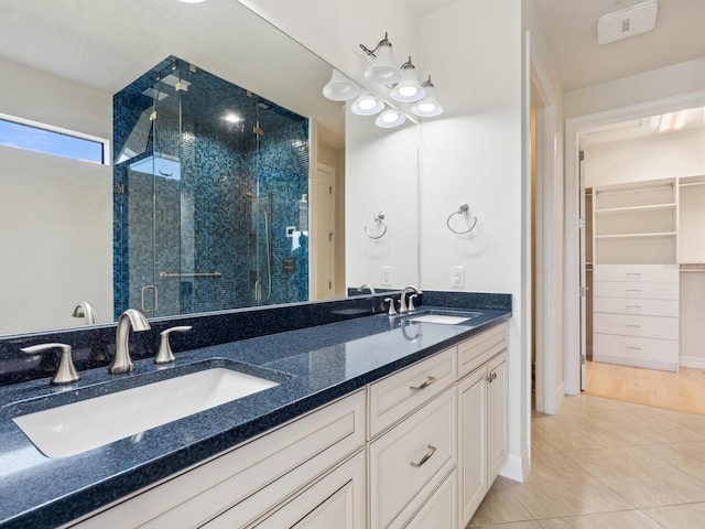 bathroom featuring tile patterned flooring, vanity, and a shower with shower door