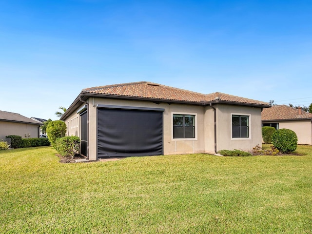 back of property featuring a yard and a garage