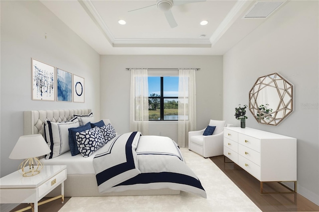 bedroom featuring a tray ceiling, ceiling fan, crown molding, and dark hardwood / wood-style floors