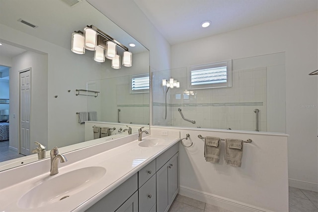 bathroom with tiled shower, vanity, and tile patterned flooring