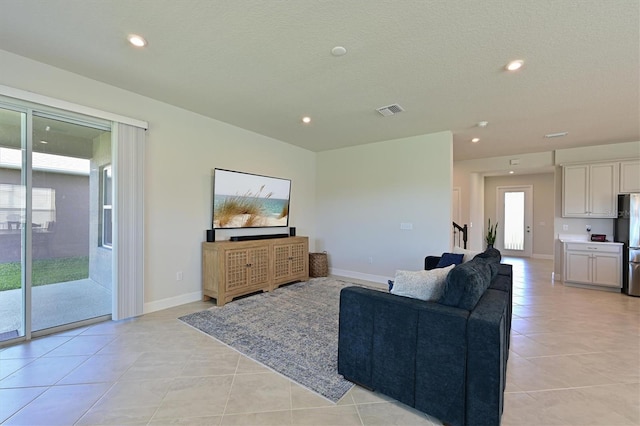 tiled living room featuring a textured ceiling