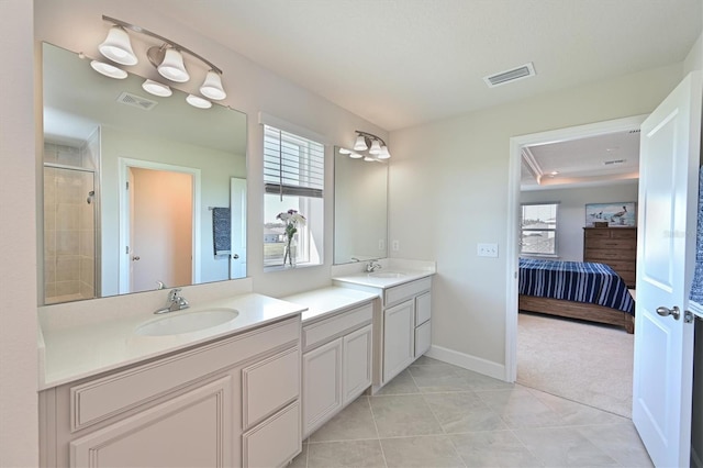 bathroom featuring tile patterned flooring, vanity, and tiled shower