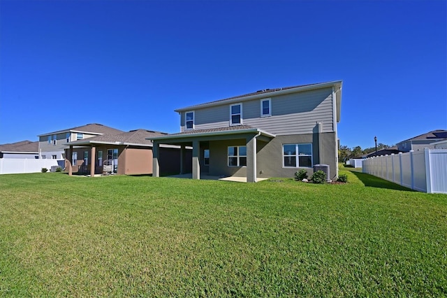 back of house with a lawn and a patio