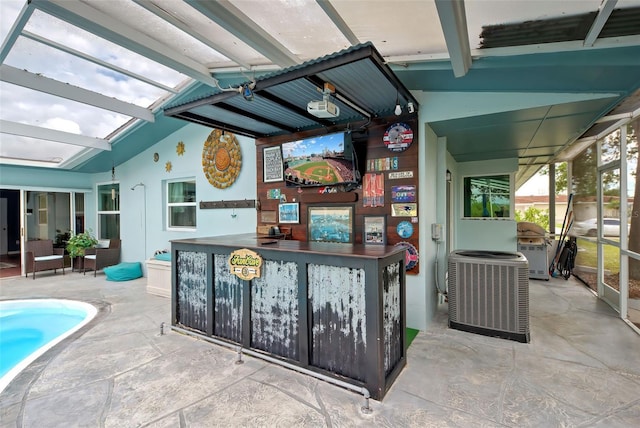 view of patio / terrace featuring central AC unit, glass enclosure, and an outdoor bar