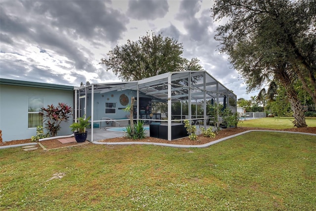 exterior space featuring a lawn and glass enclosure