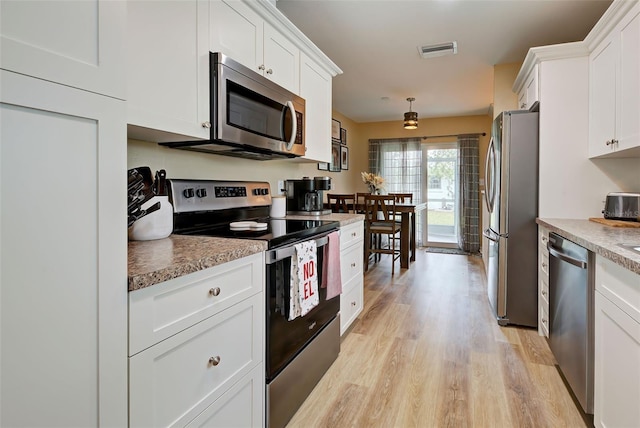 kitchen featuring appliances with stainless steel finishes, light hardwood / wood-style flooring, and white cabinetry