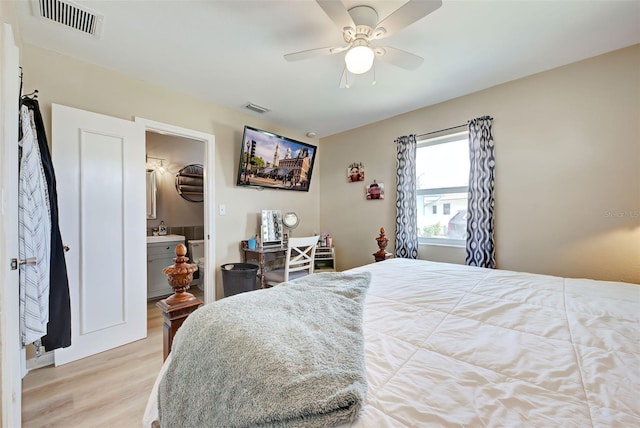 bedroom with connected bathroom, ceiling fan, sink, and light wood-type flooring