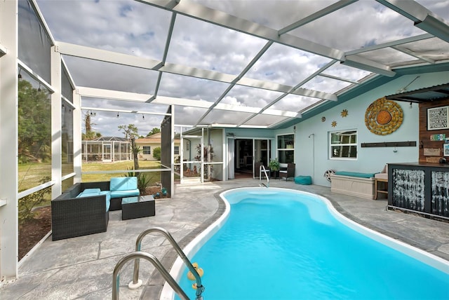 view of pool featuring glass enclosure, an outdoor hangout area, and a patio