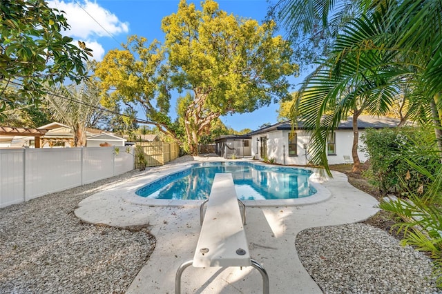 view of swimming pool with a diving board