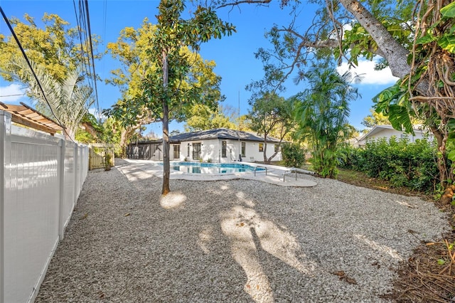 view of yard with a fenced in pool and a patio