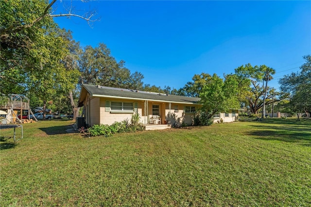 view of front of house with a playground, central AC, and a front lawn