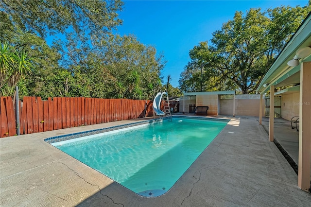 view of pool featuring a water slide and a patio