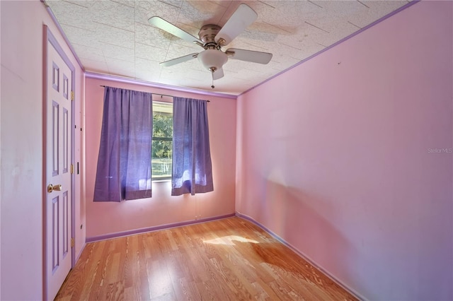 spare room featuring light wood-type flooring, ceiling fan, and ornamental molding