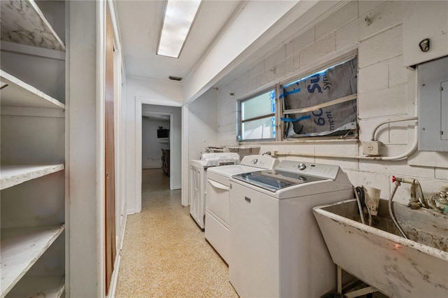 washroom with washing machine and dryer, electric panel, and sink