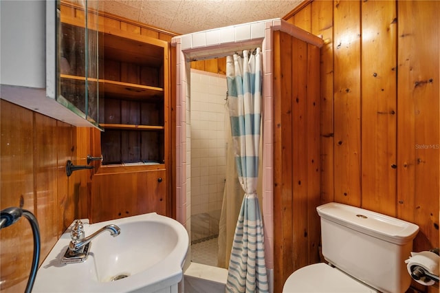 bathroom with sink, toilet, walk in shower, and wooden walls