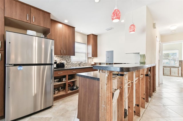 kitchen with backsplash, electric panel, stainless steel fridge, decorative light fixtures, and light tile patterned floors