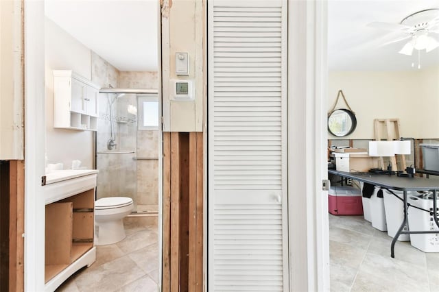 bathroom with tile patterned flooring, ceiling fan, toilet, and an enclosed shower