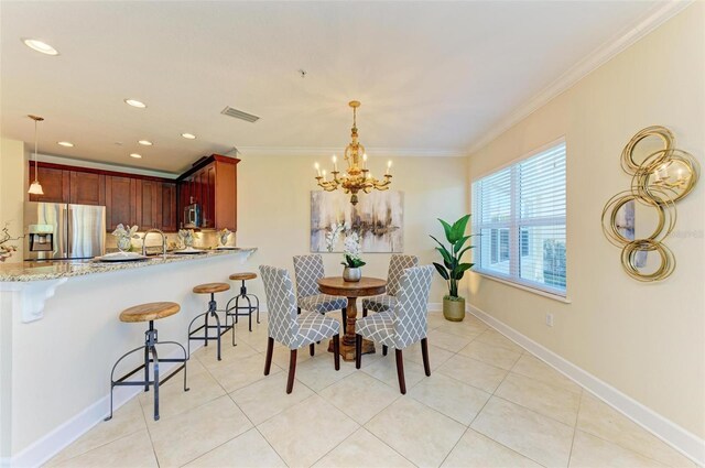 tiled dining space featuring sink, a chandelier, and ornamental molding