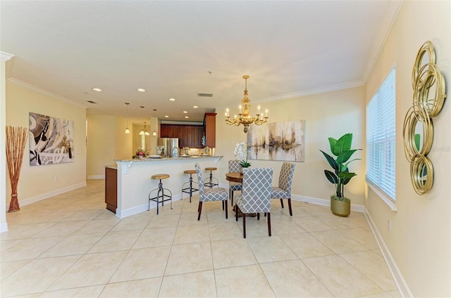 dining area featuring a notable chandelier, ornamental molding, and light tile patterned floors