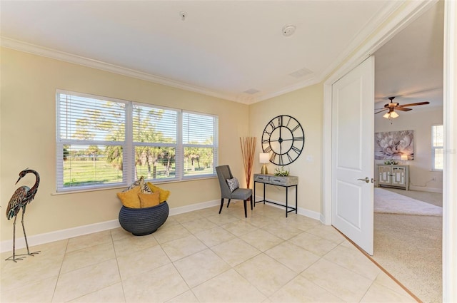 living area featuring crown molding, plenty of natural light, ceiling fan, and light colored carpet