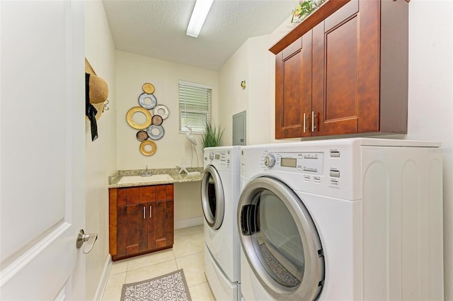 washroom with sink, cabinets, independent washer and dryer, a textured ceiling, and light tile patterned floors