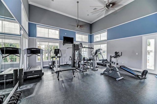 exercise room featuring a wealth of natural light, a towering ceiling, and ceiling fan