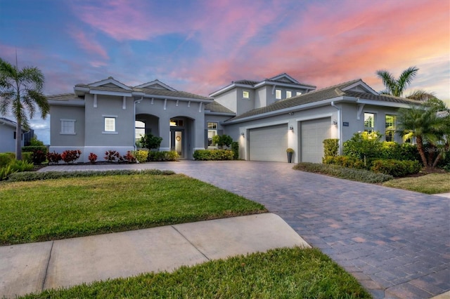 view of front of property with a yard and a garage