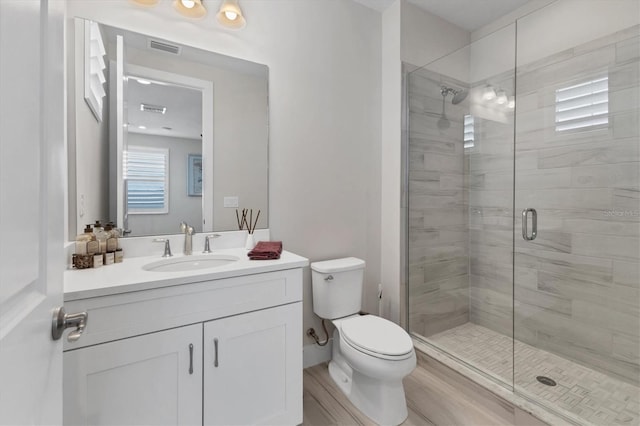 bathroom with vanity, wood-type flooring, an enclosed shower, and toilet