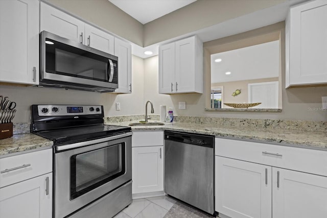 kitchen featuring light stone counters, sink, white cabinetry, and stainless steel appliances