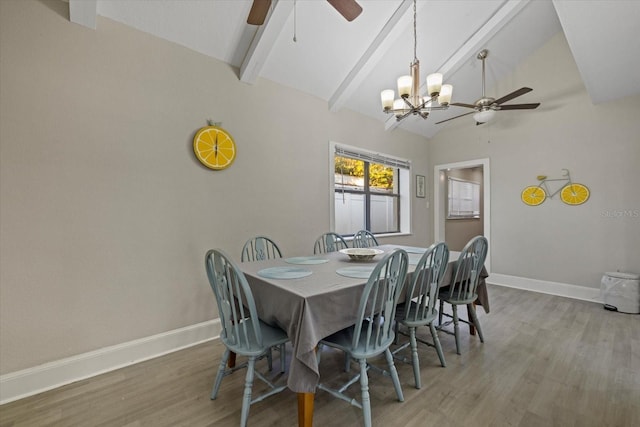 dining area featuring lofted ceiling with beams, ceiling fan with notable chandelier, and wood-type flooring