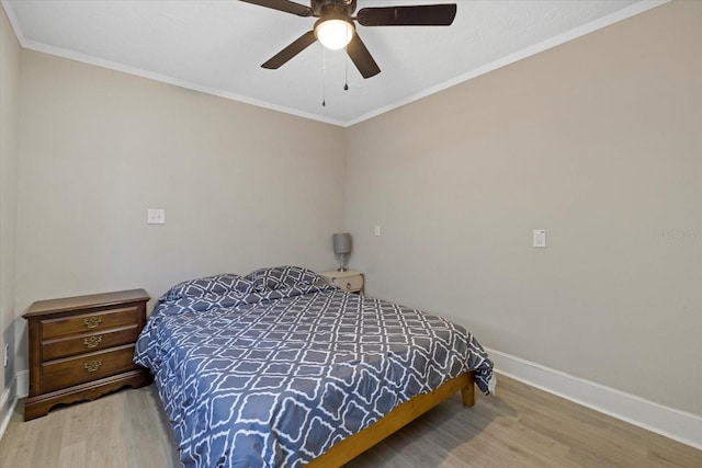 bedroom featuring hardwood / wood-style floors, ceiling fan, and ornamental molding