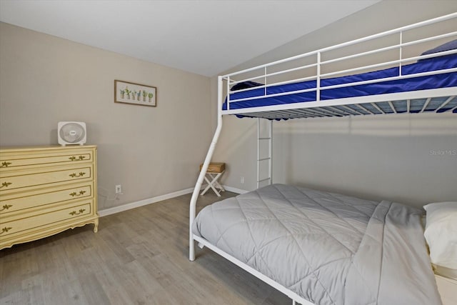 bedroom with hardwood / wood-style floors and lofted ceiling