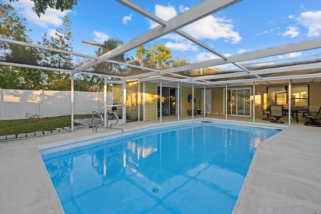 view of swimming pool featuring glass enclosure and a patio area