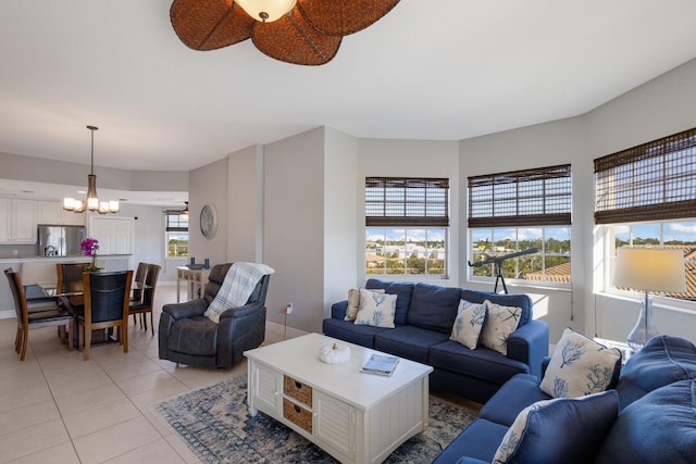 living room featuring a wealth of natural light, light tile patterned floors, and ceiling fan with notable chandelier