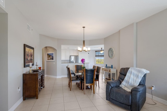 dining space with light tile patterned flooring and ceiling fan with notable chandelier