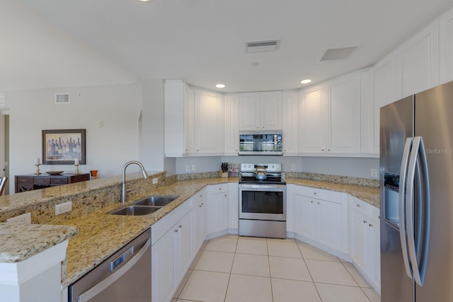 kitchen with sink, stainless steel appliances, light stone counters, kitchen peninsula, and white cabinets