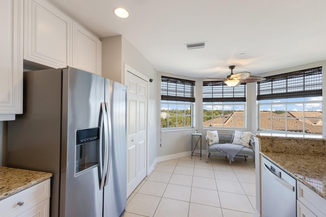 kitchen with ceiling fan, light stone counters, white cabinetry, and stainless steel appliances