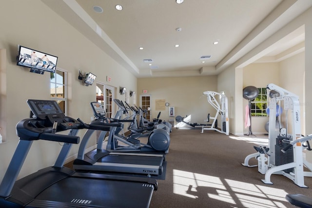 workout area with a tray ceiling