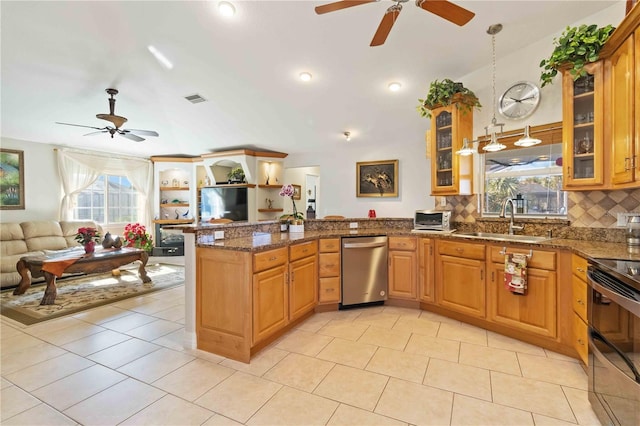 kitchen featuring backsplash, sink, dark stone countertops, light tile patterned floors, and appliances with stainless steel finishes