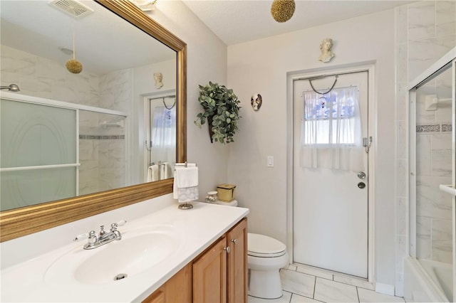 full bathroom featuring vanity, tile patterned floors, bath / shower combo with glass door, toilet, and a textured ceiling