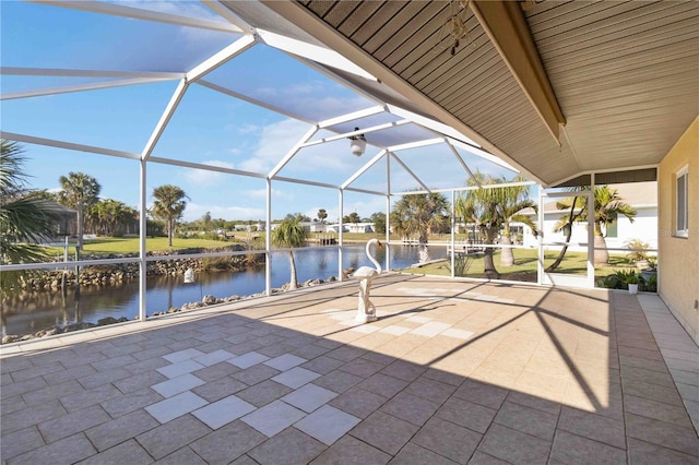 view of patio featuring a water view and glass enclosure