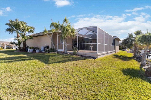 back of house with a yard and a lanai