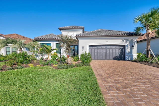 mediterranean / spanish home with a garage and a front lawn