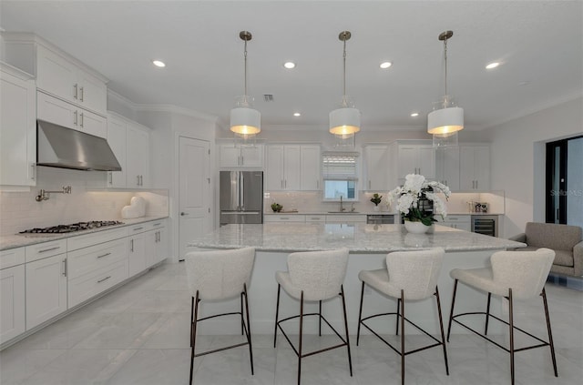 kitchen with decorative light fixtures, stainless steel appliances, white cabinetry, and a large island