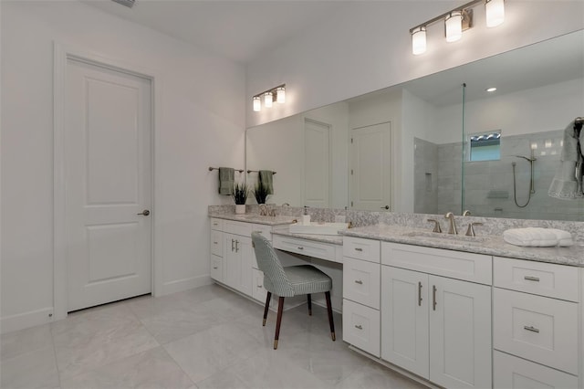 bathroom with tiled shower and vanity