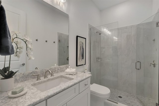 bathroom with vanity, toilet, and a shower with door