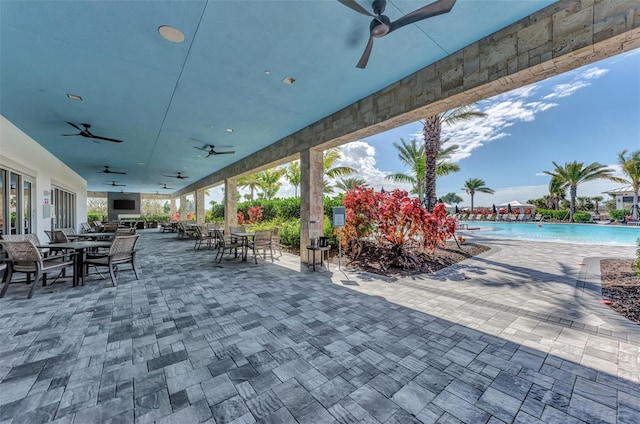 view of patio with ceiling fan and a community pool