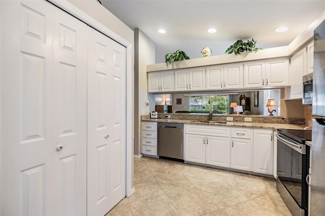 kitchen featuring light stone countertops, white cabinetry, sink, and appliances with stainless steel finishes