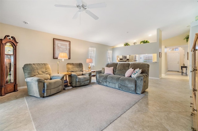 tiled living room with ceiling fan and vaulted ceiling